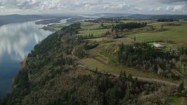 5.5K aerial stock footage flying over and tilt to Highway 14 through trees by the Columbia River, Washougal, Washington Aerial Stock Footage | AX154_196