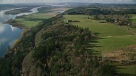 5.5K aerial stock footage of a bird's eye view of Highway 14 through forest, tilt to reveal an isolate home and green fields, Washougal, Washington Aerial Stock Footage | AX154_197E