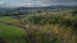 5.5K aerial stock footage flying over railroad tracks and Highway 14 beside forest near rural homes in Washougal, Washington Aerial Stock Footage | AX154_201