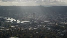 5.5K aerial stock footage of godrays shining down on Moda Center, the Willamette River and Downtown Portland, Oregon Aerial Stock Footage | AX154_224