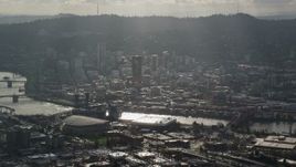 5.5K aerial stock footage of godrays coming down on Moda Center, the Willamette River and Downtown Portland, Oregon Aerial Stock Footage | AX154_225E