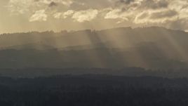 5.5K aerial stock footage of godrays shining down on mountains near Beaverton, Oregon at sunset Aerial Stock Footage | AX155_124