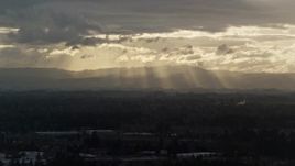5.5K aerial stock footage of distant mountains and godrays from the clouds near Beaverton, Oregon, at sunset Aerial Stock Footage | AX155_125