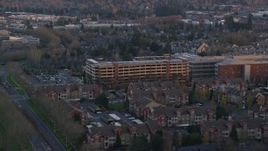 5.5K aerial stock footage flying by a large parking garage and the Kaiser Permanente Medical Offices at twilight in Hillsboro, Oregon Aerial Stock Footage | AX155_134