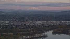 5.5K aerial stock footage of Mount Hood in the far distance at twilight, seen from a train yard in Southeast Portland, Oregon Aerial Stock Footage | AX155_169