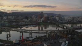 5.5K aerial stock footage of Downtown Portland skyline seen while flying by Willamette River bridges at twilight, Oregon Aerial Stock Footage | AX155_190