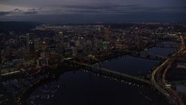 5.5K aerial stock footage flying away from KOIN Center and Downtown Portland cityscape beside the Willamette River at twilight, Oregon Aerial Stock Footage | AX155_267E
