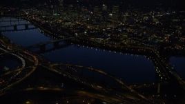 5.5K aerial stock footage of Downtown skyscrapers, Willamette River bridges, freeway interchange, and White Stag sign at night, Downtown Portland, Oregon Aerial Stock Footage | AX155_297