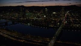 5.5K aerial stock footage of a view across the Burnside Bridge and Willamette River of Downtown Portland and the White Stag Sign, Oregon, at night Aerial Stock Footage | AX155_317E