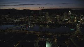 5.5K aerial stock footage of Downtown Portland skyscrapers at night seen across the Hawthorne Bridge and Willamette River, Oregon Aerial Stock Footage | AX155_320