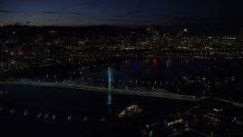 5.5K aerial stock footage flying by Tilikum Crossing, with Downtown Portland skyline in the distance, Oregon, night Aerial Stock Footage | AX155_323E
