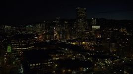5.5K aerial stock footage approaching and passing US Bancorp Tower and skyscrapers by the Willamette River at nighttime, Downtown Portland, Oregon Aerial Stock Footage | AX155_365E
