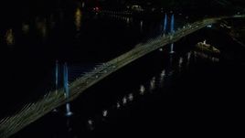 5.5K aerial stock footage orbiting Tilikum Crossing bridge as a commuter train crosses the span at night in South Portland, Oregon Aerial Stock Footage | AX155_416E
