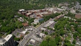 4.8K aerial stock footage following Peachtree Road past hospital, reveal office buildings and wooded areas, Buckhead Aerial Stock Footage | AX36_047E
