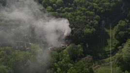 4.8K aerial stock footage approach and tilt to smoke rising from a house fire in a wooded area, West Atlanta, Georgia Aerial Stock Footage | AX38_048E