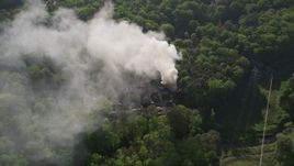 4.8K aerial stock footage fly away from smoke, then approach and tilt to bird's eye of a burning house, West Atlanta Aerial Stock Footage | AX38_054E