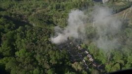 4.8K aerial stock footage of smoke rising from a house fire in a wooded area, West Atlanta Aerial Stock Footage | AX38_057