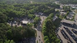 4.8K aerial stock footage flying over a parkway and auto parts yard near trees, West Atlanta Aerial Stock Footage | AX38_083