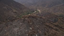 5K aerial stock footage fly over scorched ridge of Santa Monica Mountains and approach an isolated rural home, California Aerial Stock Footage | AX42_008