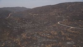 5K aerial stock footage approach a mountain road winding around the fire-damaged slopes of Santa Monica Mountains, California Aerial Stock Footage | AX42_010