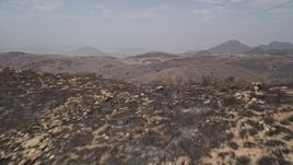 5K aerial stock footage fly over a fire-damaged slope to reveal barren, less damaged Santa Monica Mountains, California Aerial Stock Footage | AX42_011