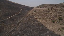 5K aerial stock footage fly low to follow a mountain road over a ridge, Santa Monica Mountains, California Aerial Stock Footage | AX42_018