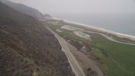 5K aerial stock footage of following coastal Highway 1 with light traffic toward the ocean, Point Mugu, California Aerial Stock Footage | AX42_054E