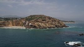 5K aerial stock footage of a sparsely populated beach and Point Dume, seen from the ocean, Malibu, California Aerial Stock Footage | AX42_086E