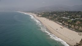 5K aerial stock footage fly over the Pacific Ocean away from the sparsely populated beach in Malibu, California Aerial Stock Footage | AX42_093