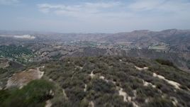 5K aerial stock footage of flying low over Santa Monica Mountains to reveal Calabasas, California Aerial Stock Footage | AX42_117