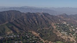 4K aerial stock footage tilting from the Hollywood Reservoir to reveal and approach the Hollywood sign, Los Angeles, California Aerial Stock Footage | AX43_008