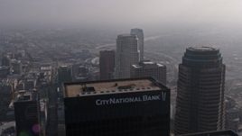 4K aerial stock footage flying by US Bank Tower, and over City National Plaza and Paul Hastings  Tower on a foggy day, Downtown Los Angeles, California Aerial Stock Footage | AX43_027E