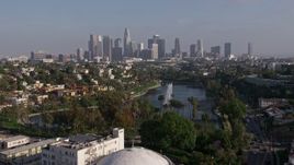 4K aerial stock footage flying over Echo Park Lake fountain to approach Downtown Los Angeles skyline, California Aerial Stock Footage | AX43_043E