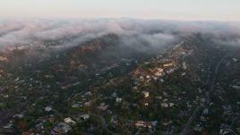 4K aerial stock footage of upscale hillside homes with fog rolling over the hills, Sherman Oaks, California, sunset Aerial Stock Footage | AX44_003