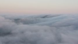 4K aerial stock footage of radio tower peaking through a marine layer, Hollywood Hills, California, sunset Aerial Stock Footage | AX44_015