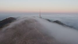 4K aerial stock footage of the Marine Layer rolling over Hollywood Hills, Los Angeles, California, sunset Aerial Stock Footage | AX44_020E