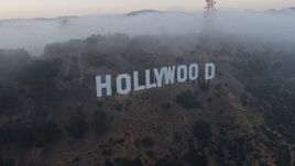 4K aerial stock footage approaching radio tower peeking through marine layer, reveal the Hollywood Sign, California, sunset Aerial Stock Footage | AX44_026E