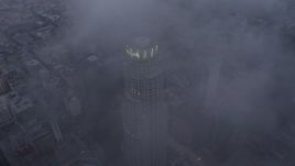 4K aerial stock footage fly over the city covered in fog, tilt to reveal skyscraper in Downtown Los Angeles, California, twilight Aerial Stock Footage | AX44_036E