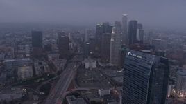 4K aerial stock footage approaching skyscrapers below marine layer, Downtown Los Angeles, twilight Aerial Stock Footage | AX44_048