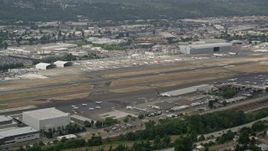 5K aerial stock footage flying by Boeing Field with a row of commercial planes on the other side of the runways, Seattle, Washington Aerial Stock Footage | AX45_007E