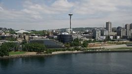 5K aerial stock footage flying by Waterfront piers and office buildings with Space Needle in background, Downtown Seattle, Washington Aerial Stock Footage | AX45_099E