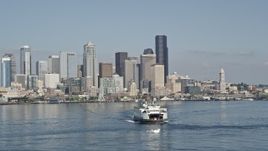 5K aerial stock footage fly low to track a ferry crossing Elliott Bay, reveal Downtown Seattle skyline, Washington Aerial Stock Footage | AX47_033E