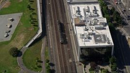 5K aerial stock footage track a commuter train passing a park in the Seattle Waterfront in Downtown Seattle, Washington Aerial Stock Footage | AX47_062