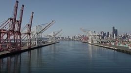 5K aerial stock footage flyby cranes and over the Duwamish Waterway at Harbor Island toward Downtown Seattle skyline, Washington Aerial Stock Footage | AX47_103E