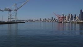 5K aerial stock footage fly low over between Harbor Island cargo cranes, and approach the Seattle skyline, Washington Aerial Stock Footage | AX47_105