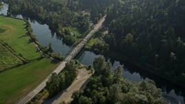 5K aerial stock footage fly over a green field to approach a small bridge spanning the Snoqualmie River in Carnation, Washington Aerial Stock Footage | AX48_030