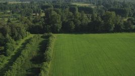5K aerial stock footage fly over green field, trees, and a bend in the river to reveal a golf course, Carnation, Washington Aerial Stock Footage | AX48_034