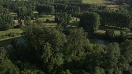 5K aerial stock footage fly over green field, trees, and a bend in the river to reveal a golf course, Carnation, Washington Aerial Stock Footage | AX48_034E