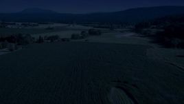4K day for night color corrected aerial stock footage of crop fields and a country road near a greenhouse in Carnation, Washington Aerial Stock Footage | AX48_040_DFN