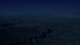 4K day for night color corrected aerial stock footage of a vast evergreen forest, and approach a clear cut area in King County, Washington Aerial Stock Footage | AX48_046_DFN